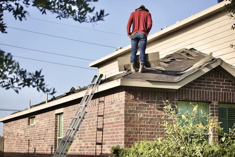 Professional roofer working on a residential roof in Tower Oaks